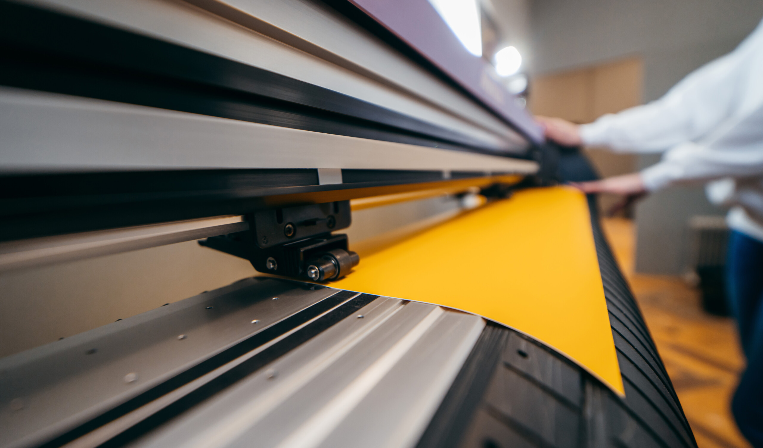 female-hands-holding-yellow-printable-material-alarge-format-printing-plotter-graphic-design We produce your vehicle graphics and quality check each print!